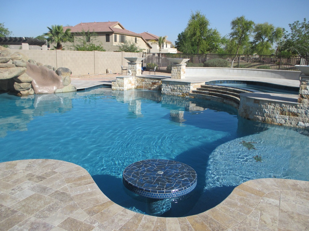 Bright Arizona backyard pool remodel with blue water and custom stone